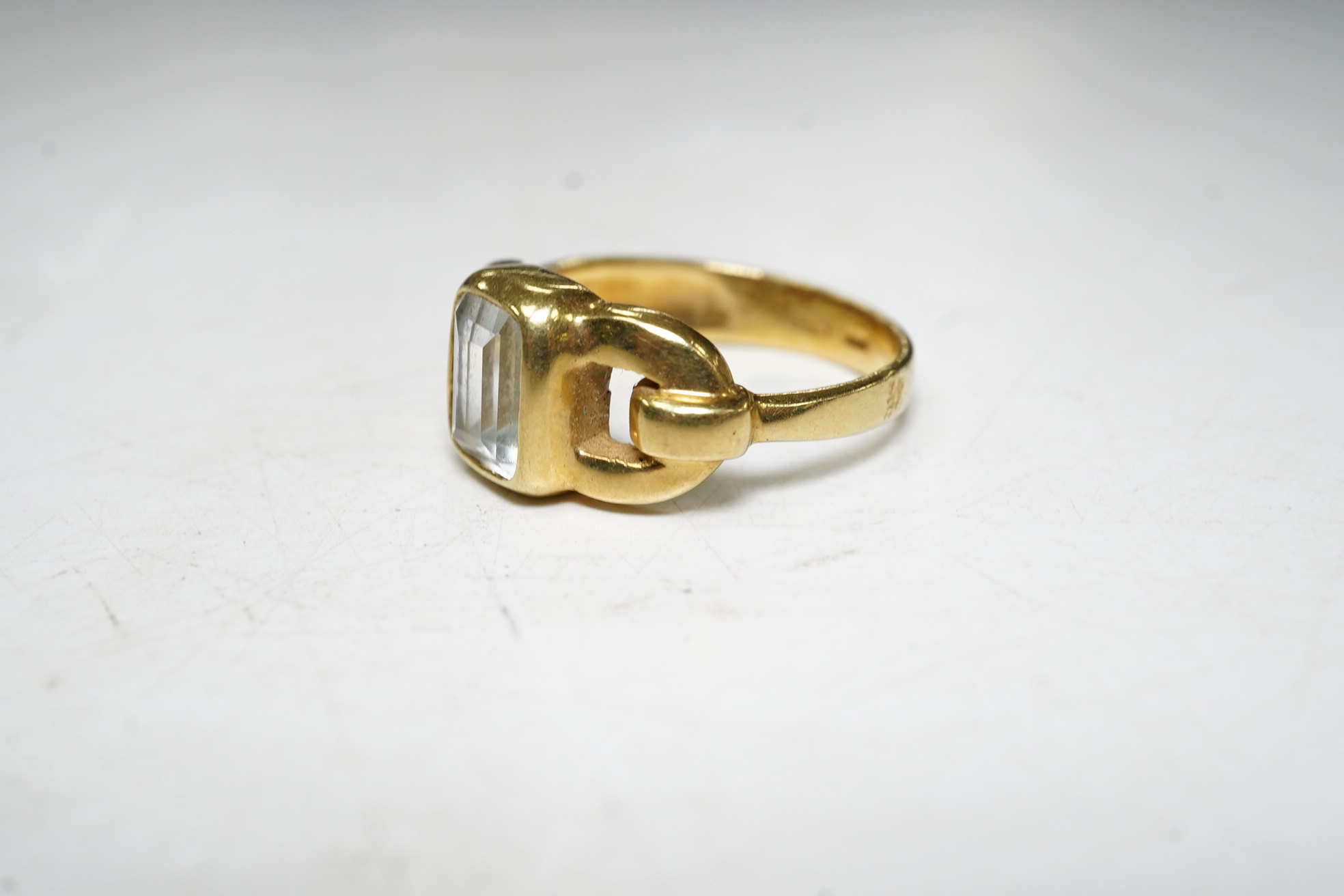 An 18ct gold aquamarine set buckle ring, size O, gross 6.1 grams Condition, fair.